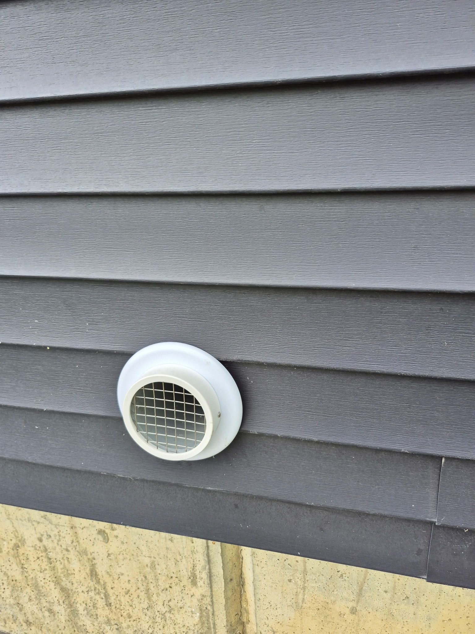 Exterior radon vent cap installed on home siding – Radon Plus mitigation system