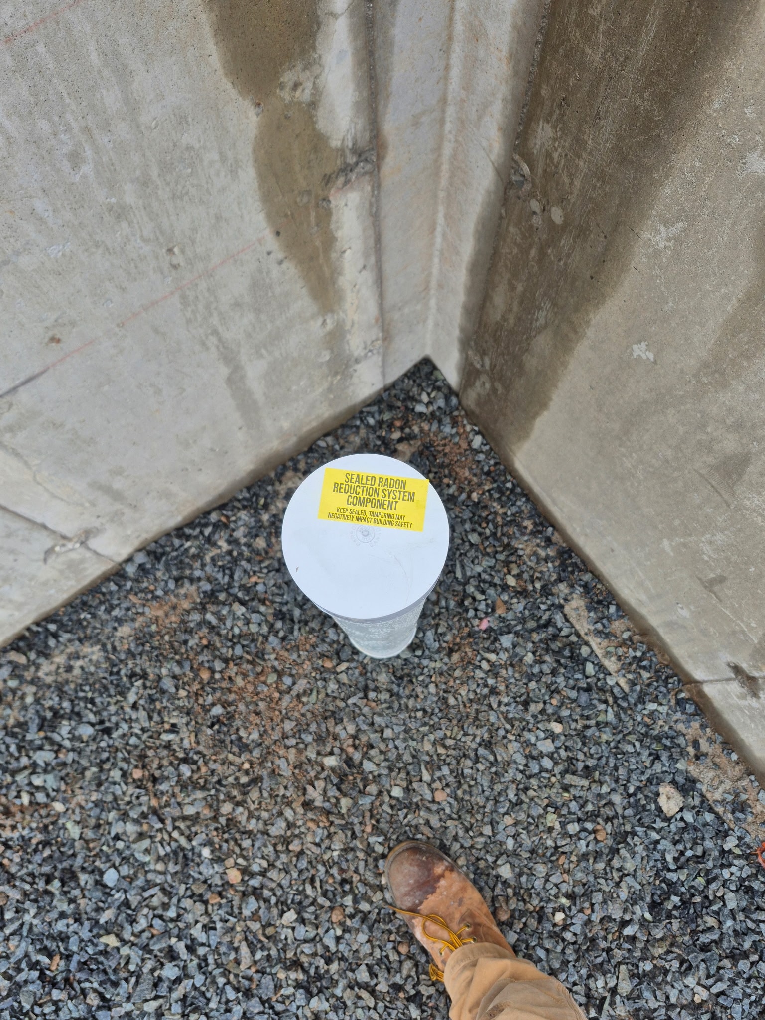 Radon mitigation system suction point installed at foundation